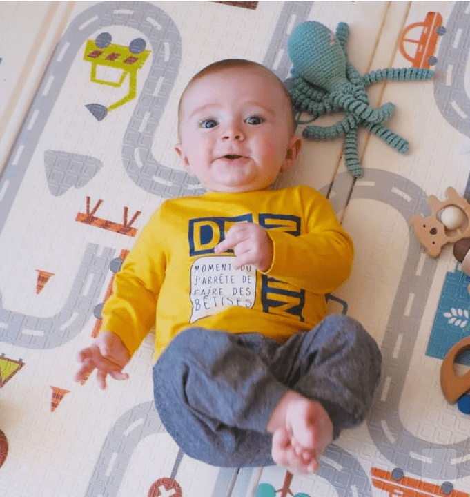 bebé tumbado en alfombra de juegos para bebés